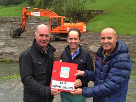 Der Projektleiter Urs Bollmann nimmt die Baubewilligung von Norbert Patt und Peter Reinle in Empfang.